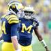 Michigan junior quarterback Denard Robinson smiles as he warms up with his teammates during pregame at the first-ever night game at Michigan Stadium on Saturday. Melanie Maxwell I AnnArbor.com